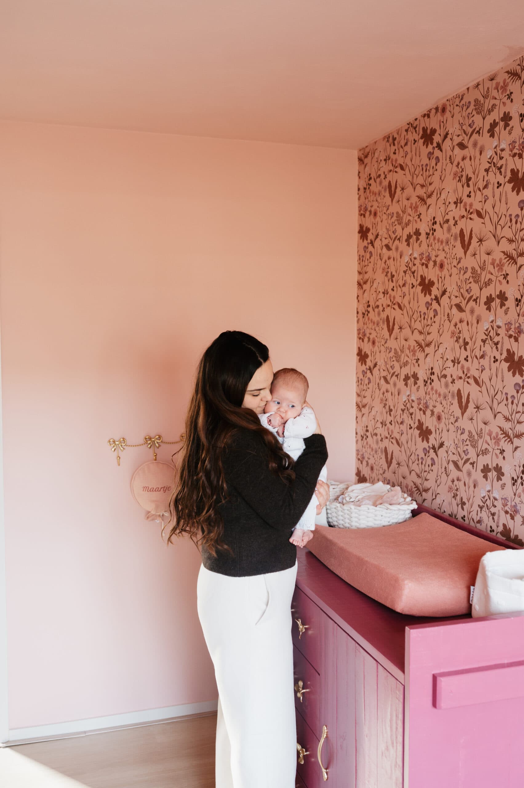 Moeder met baby in roze babykamer – Studio Roos Fotografie