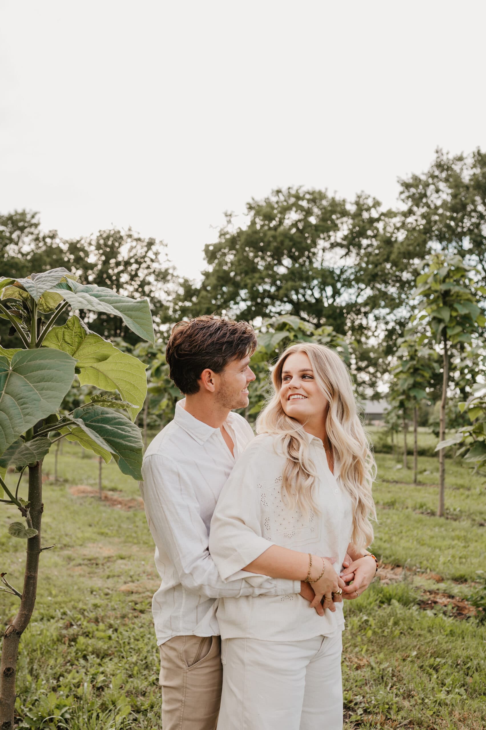 Loveshoot van een stel tussen jonge bomen – Studio Roos Fotografie
