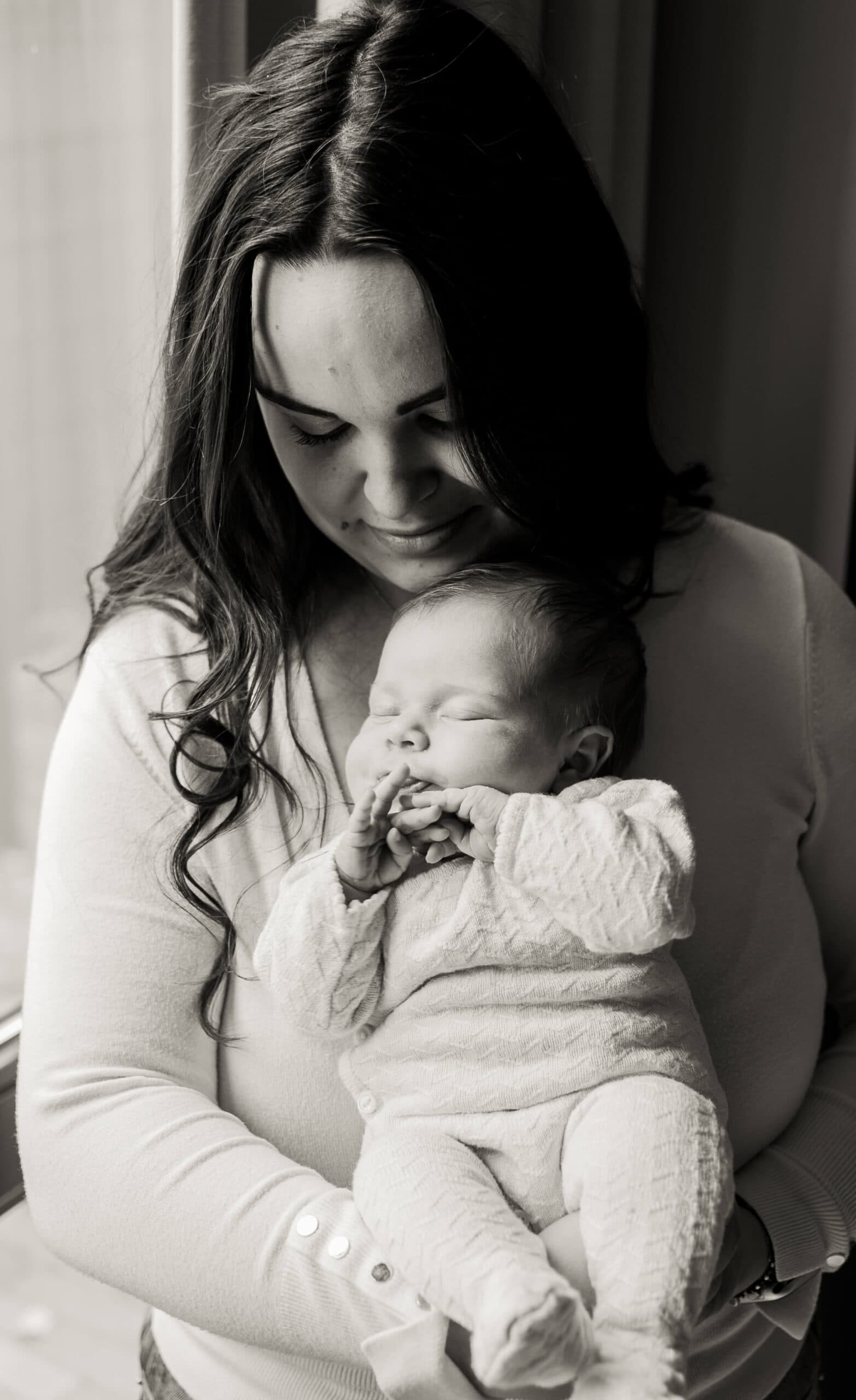 Moeder wiegt haar slapende newborn, zwart-wit – Studio Roos Fotografie