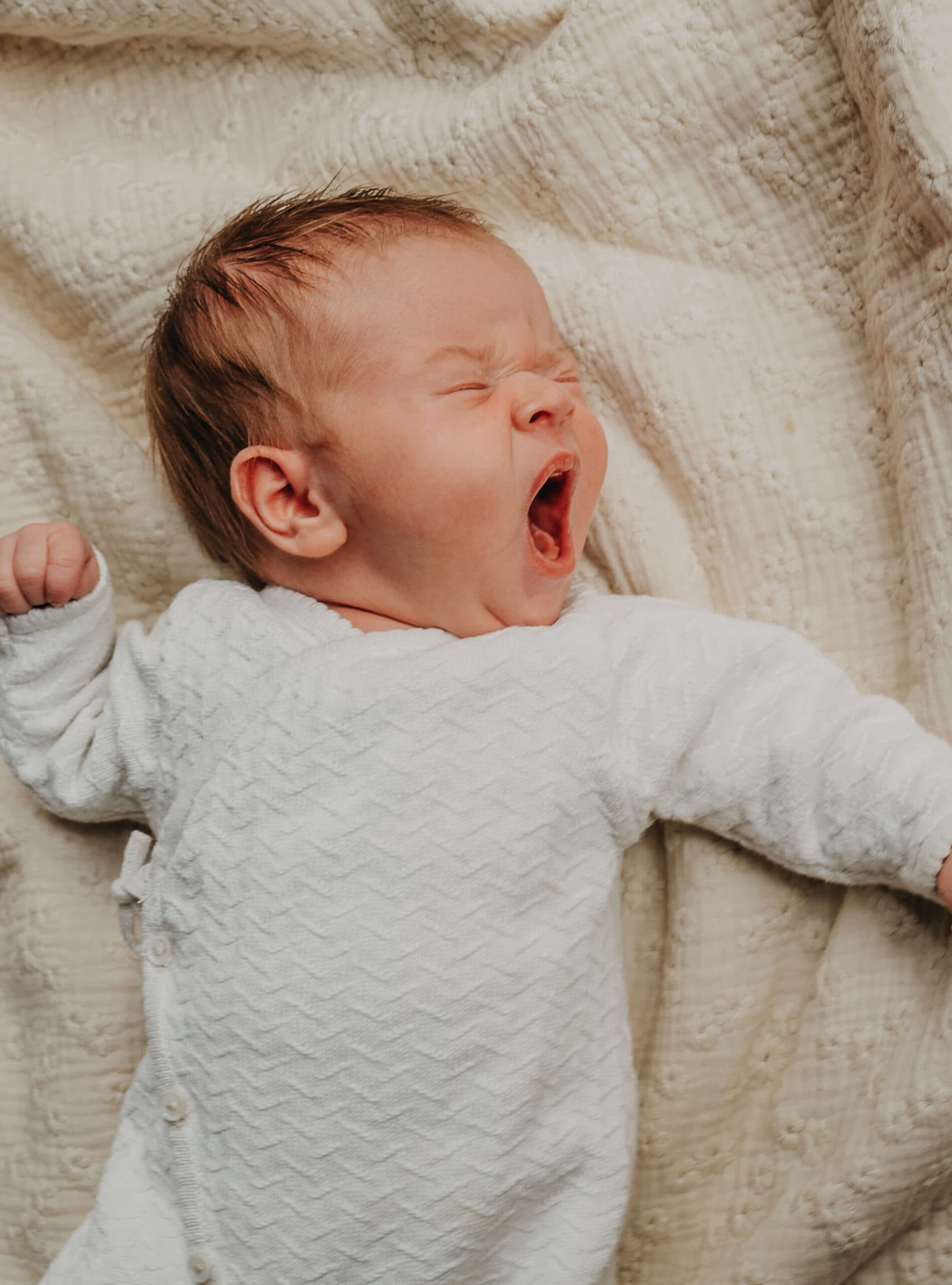Gapende newborn op zachte deken – Studio Roos Fotografie