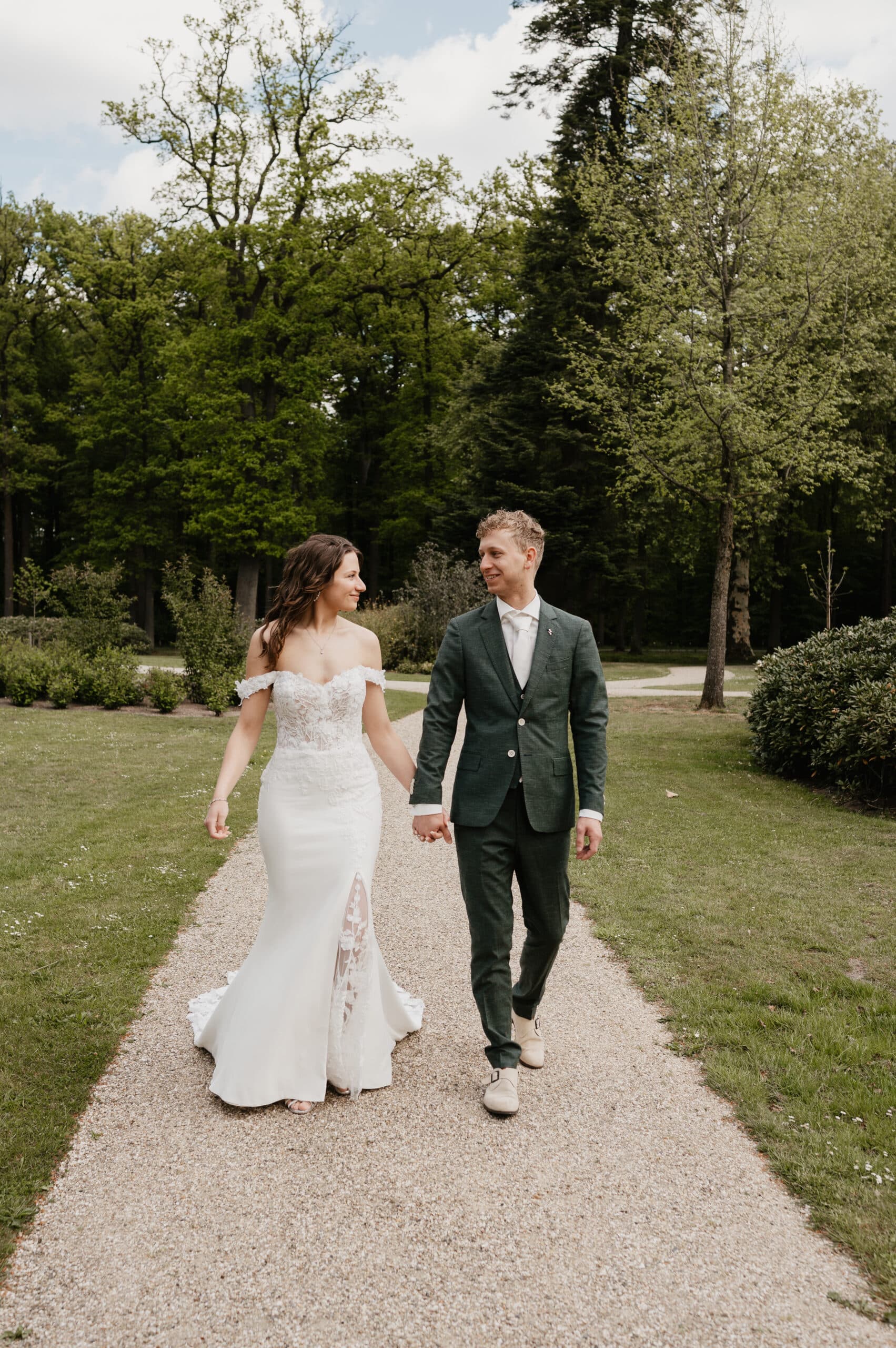 Bruidspaar loopt hand in hand door het park – Studio Roos Fotografie