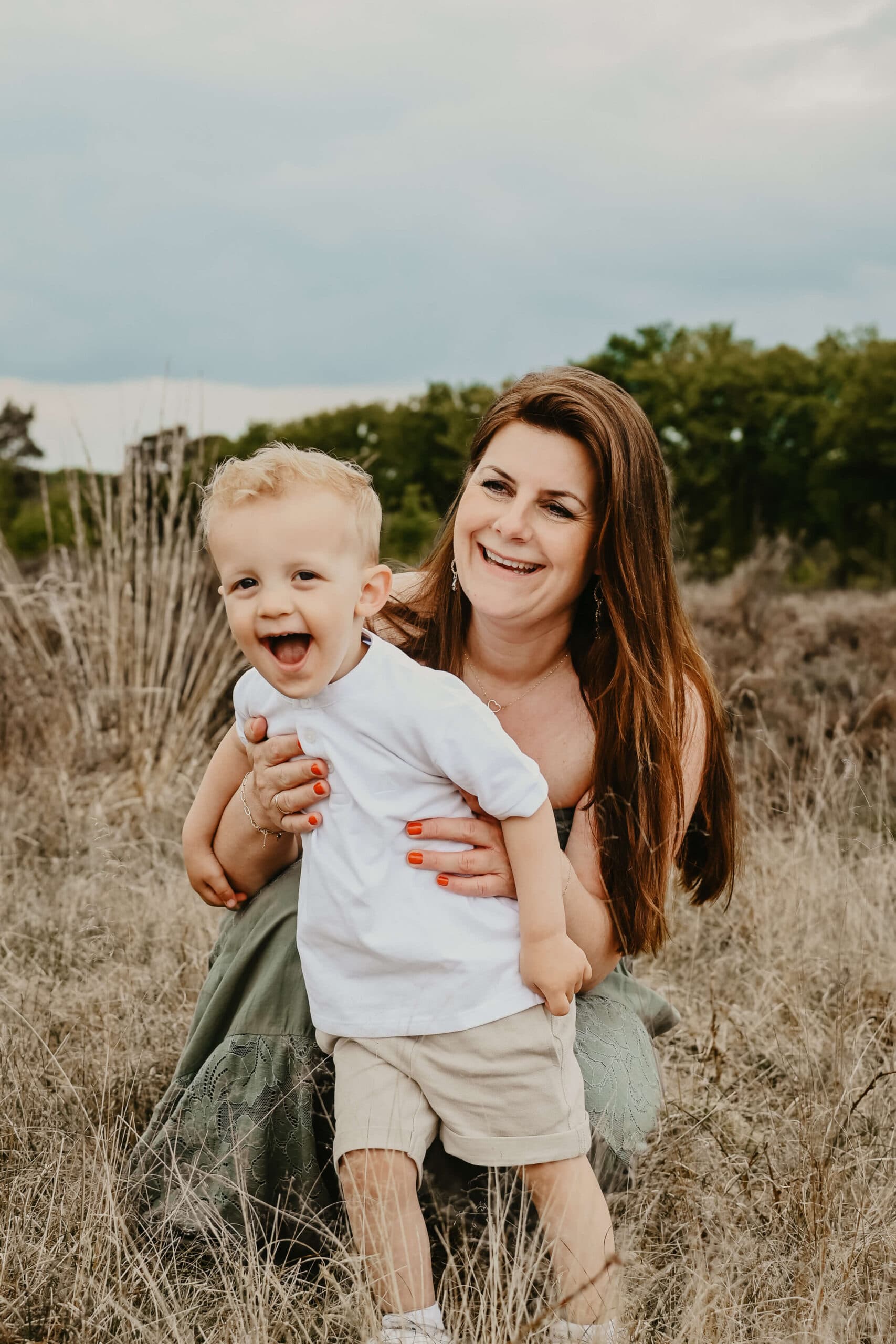 Moeder lacht met haar zoontje in het veld – Studio Roos Fotografie