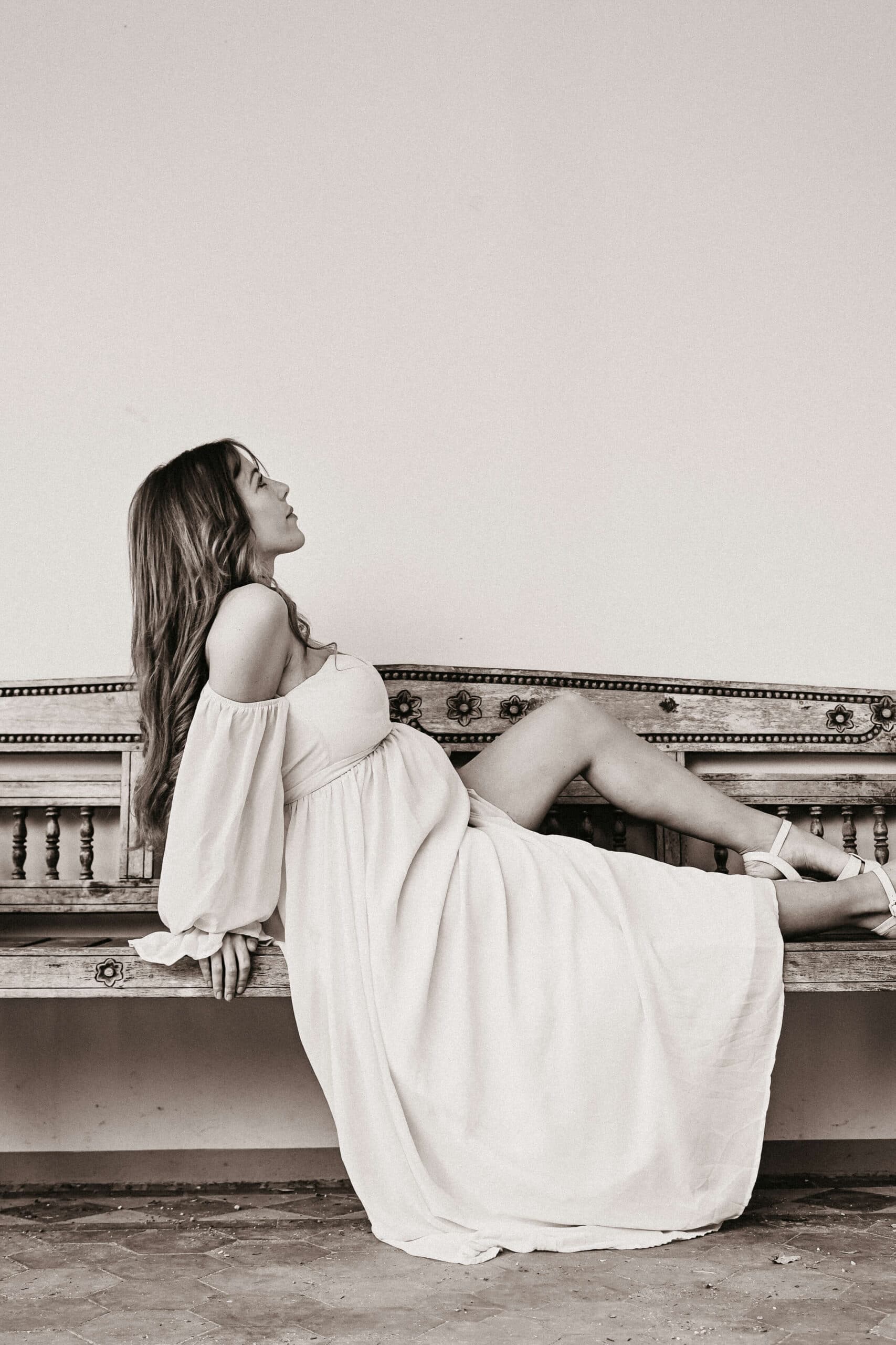 Zwangere vrouw op houten bank, sepia – Studio Roos Fotografie