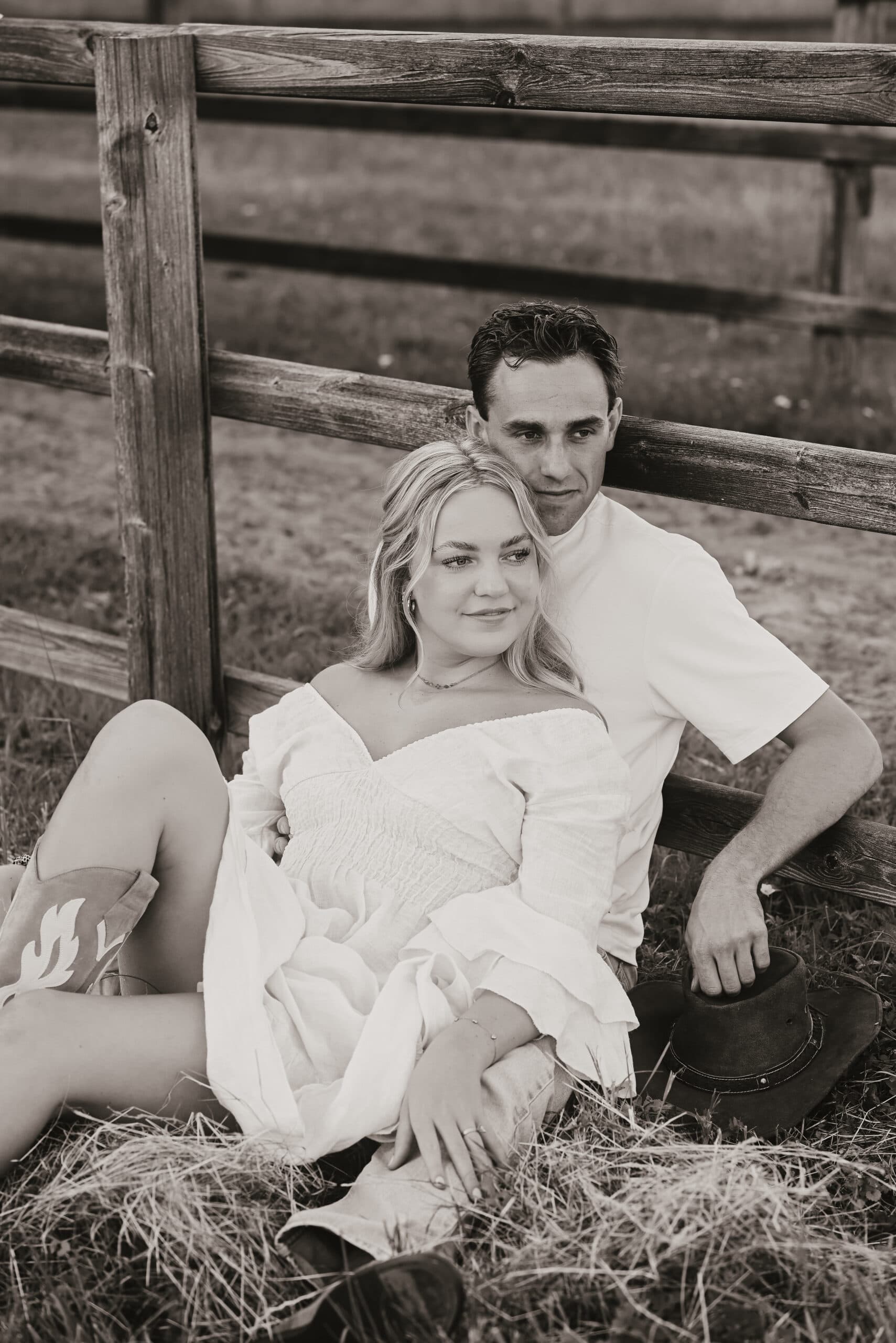 Stel leunt ontspannen tegen houten hek in weiland – Studio Roos Fotografie