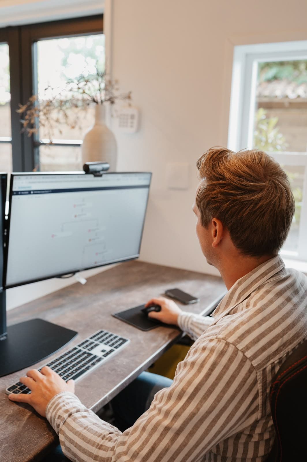 Ondernemer aan het werk achter twee beeldschermen – Studio Roos Fotografie