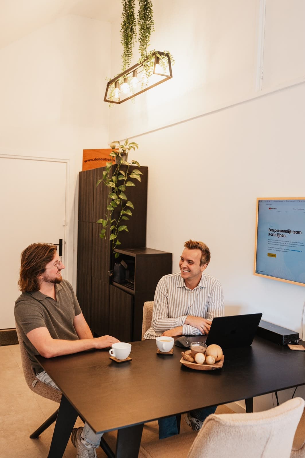 Twee ondernemers in gesprek aan de vergadertafel met koffie – Studio Roos Fotografie