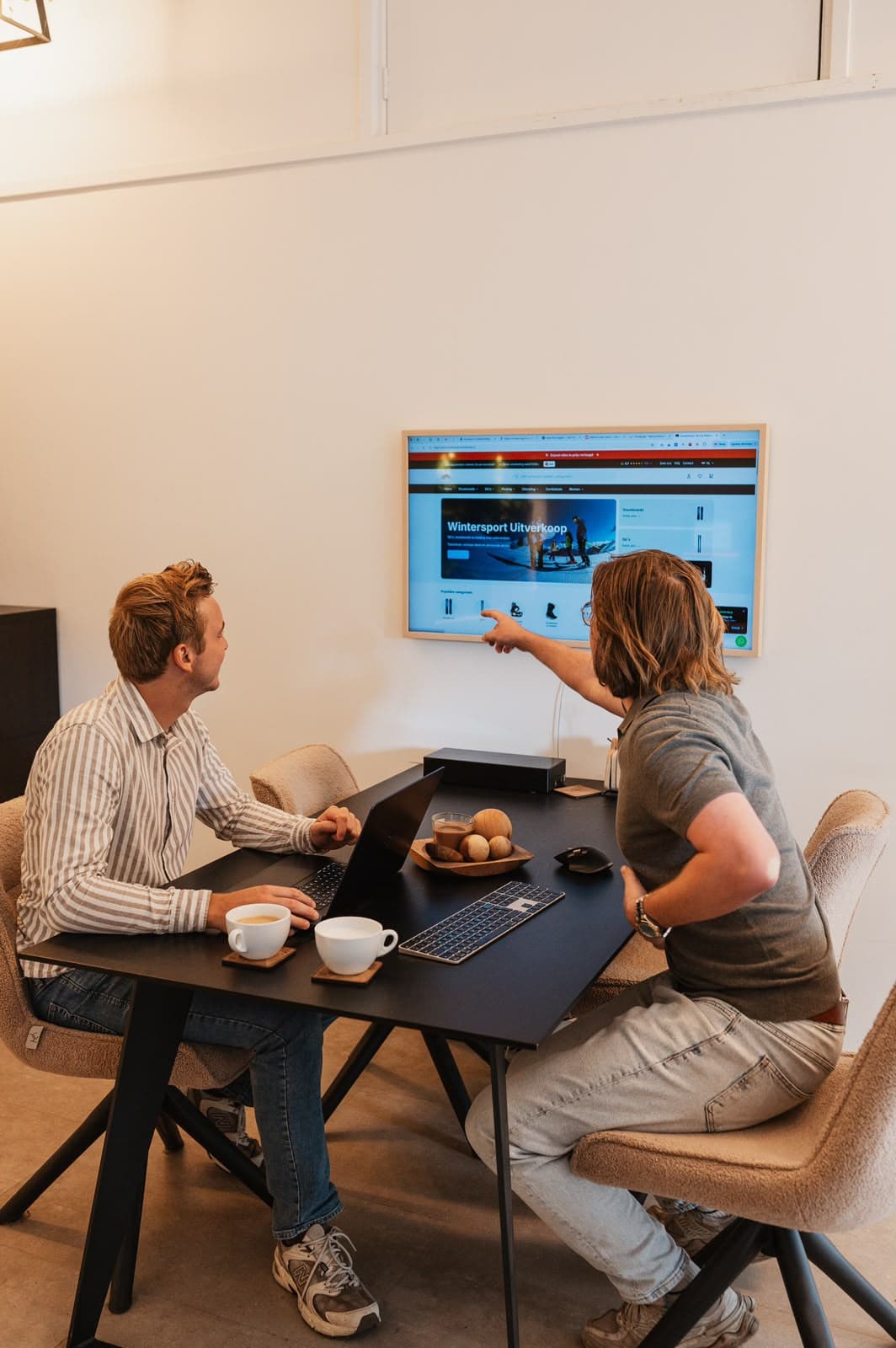Twee ondernemers bekijken samen een website op een wandscherm – Studio Roos Fotografie