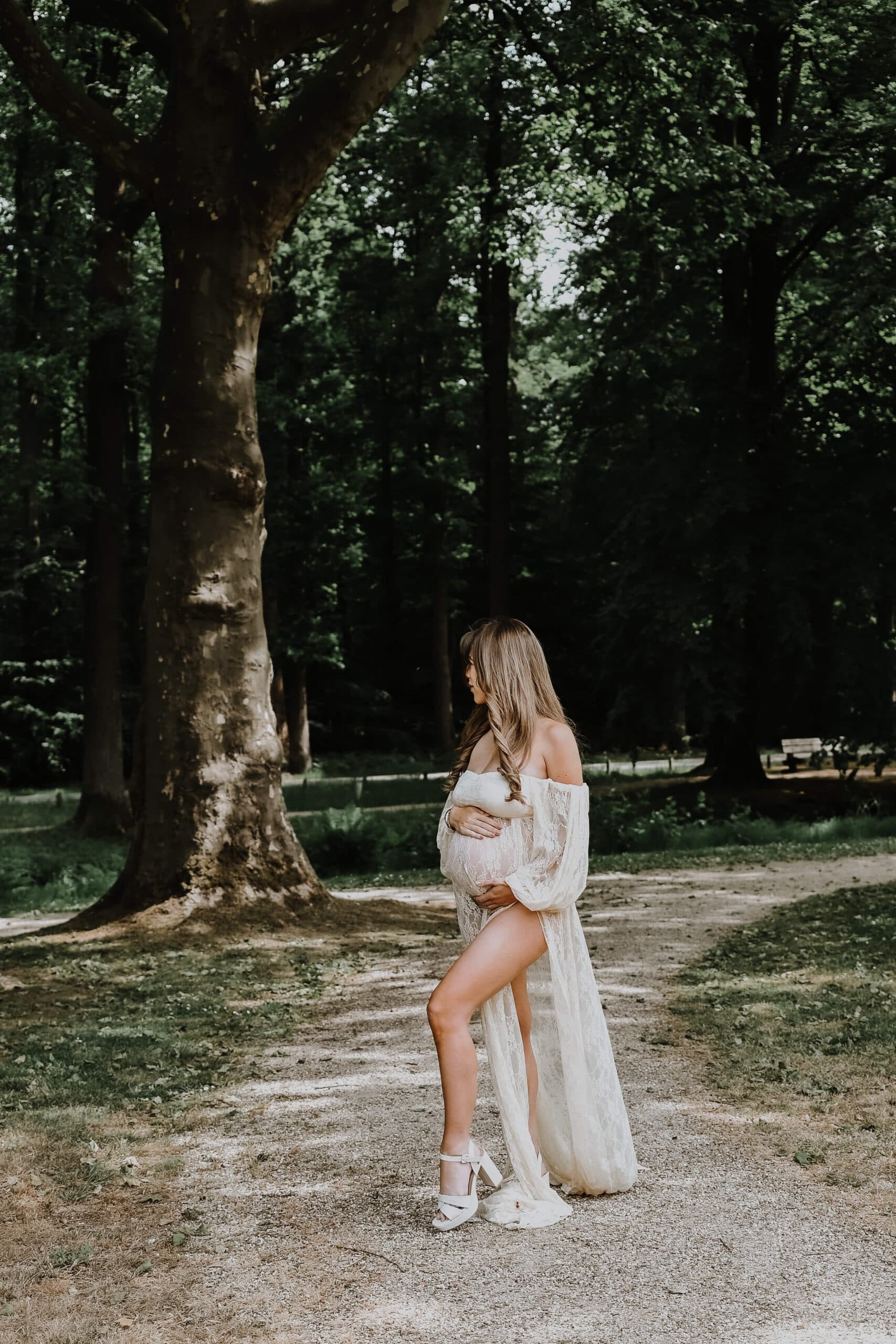 Zwangere vrouw in lange jurk op bospad – Studio Roos Fotografie